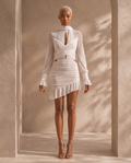 Front view of the Ivory Veil ruched mesh mini dress on the BLANC LOVE main model in a warm beige architectural setting
